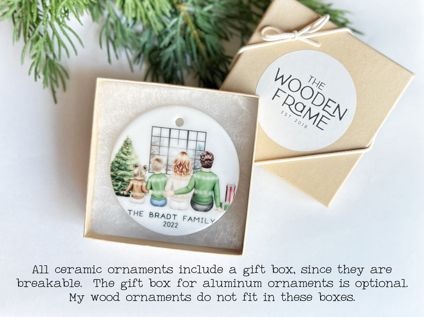a ceramic ornament in a gift box, with a wooden frame, and a label indicating that it is a family ornament.