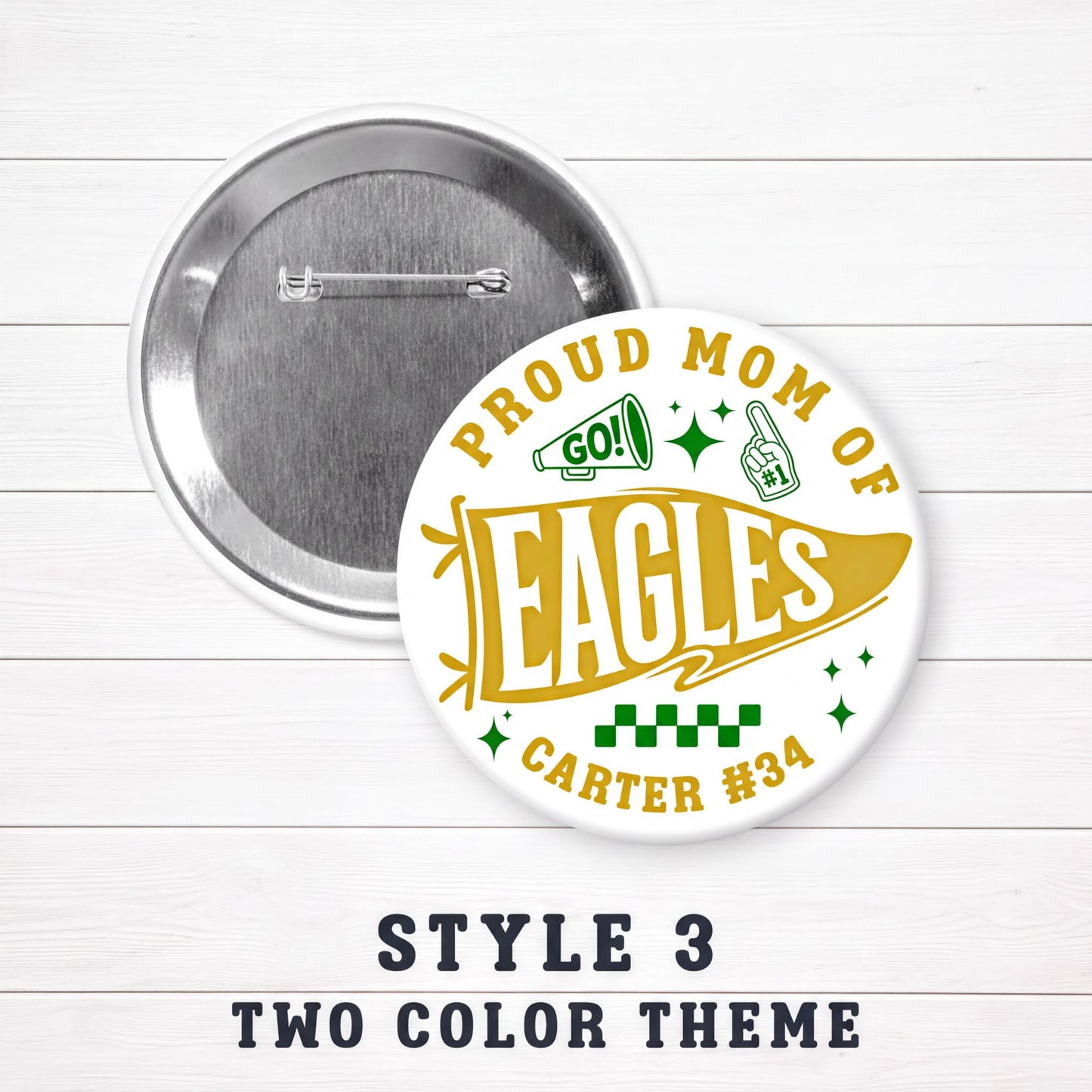 a round pin with a design that says "PROUD MOM OF EAGLES" and "CARTER #34". The pin is set against a white background with a wooden texture.