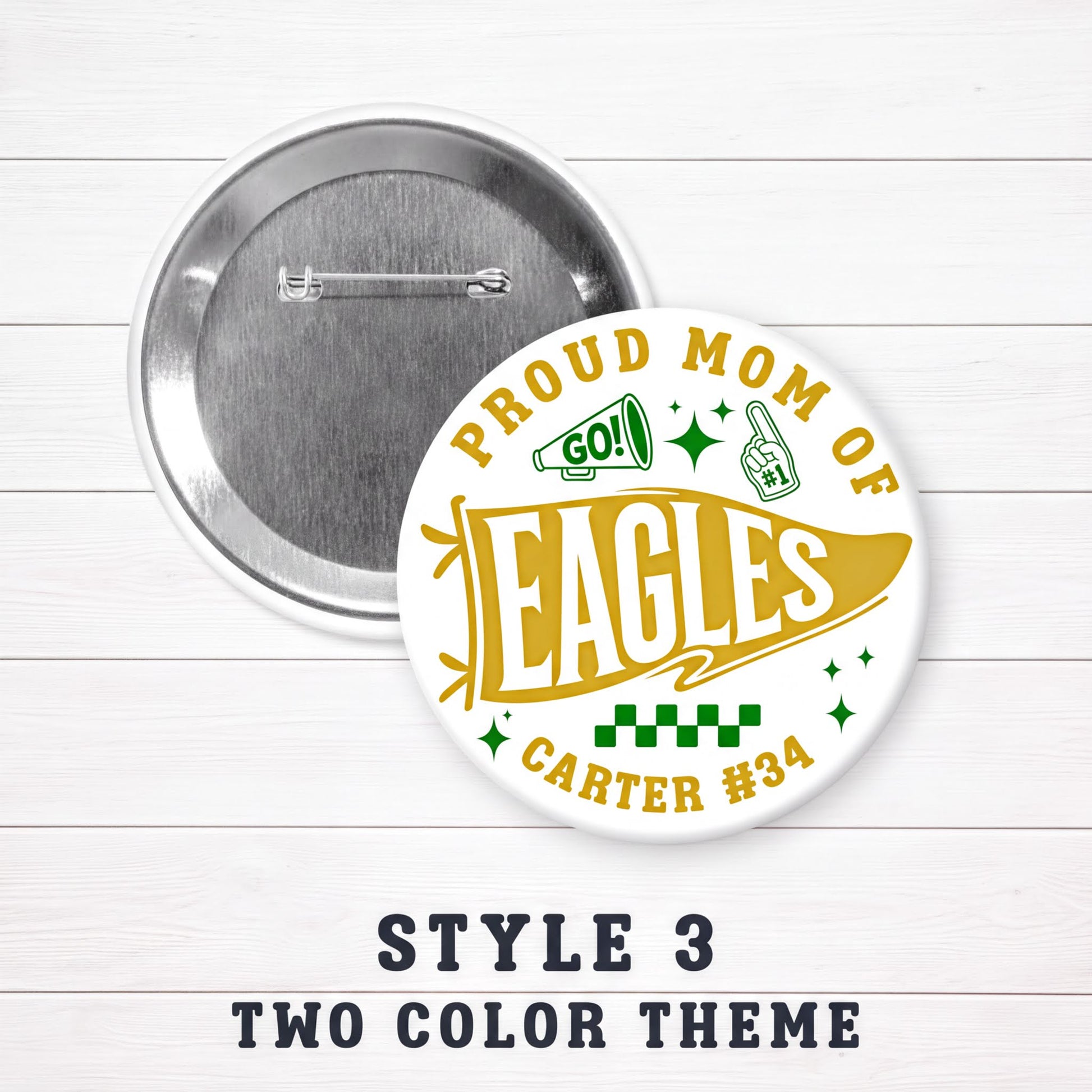 a round pin with a design that says "PROUD MOM OF EAGLES" and "CARTER #34". The pin is set against a white background with a wooden texture.