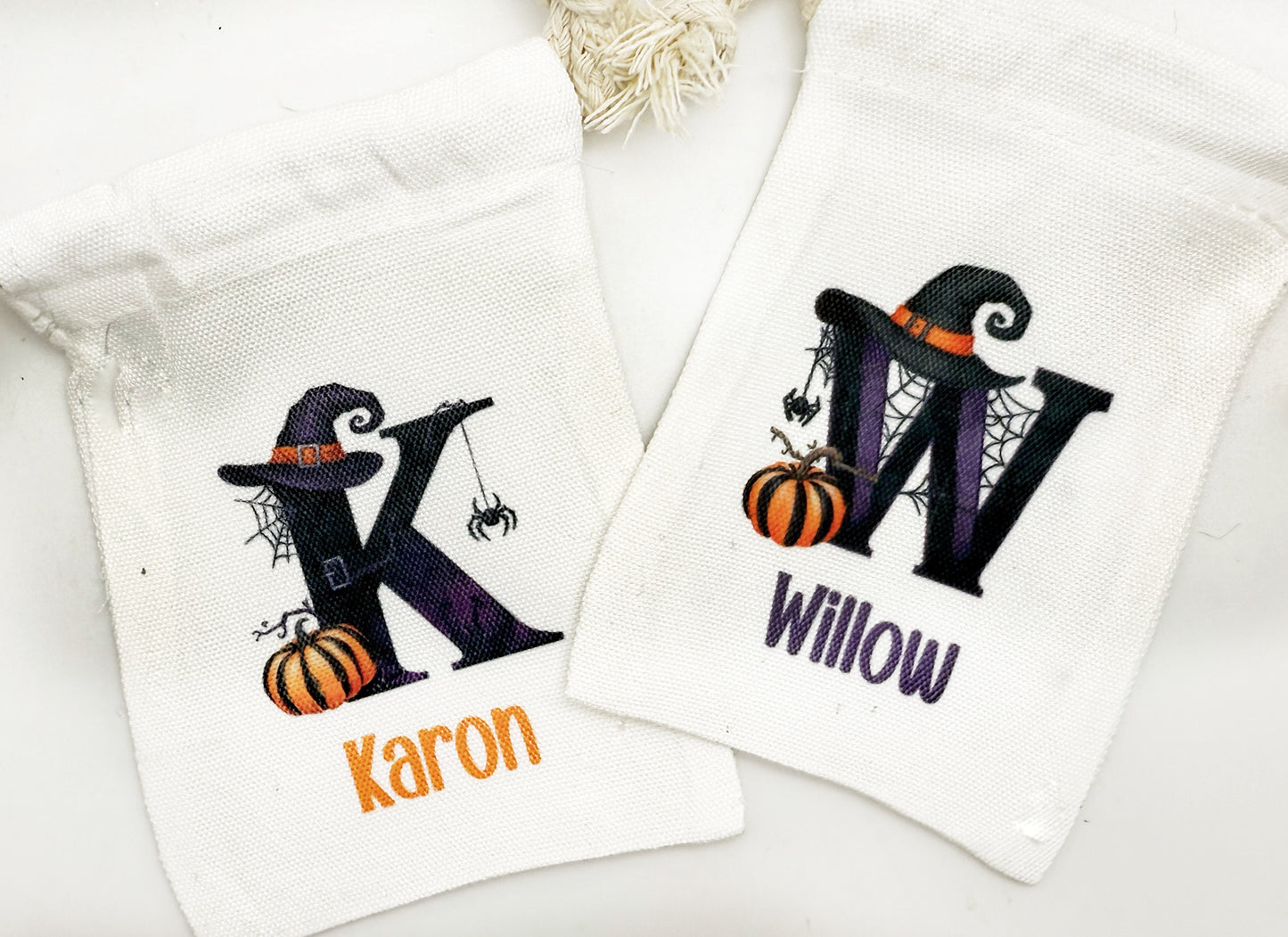 two white towels with personalized monogrammed letters and Halloween-themed illustrations.