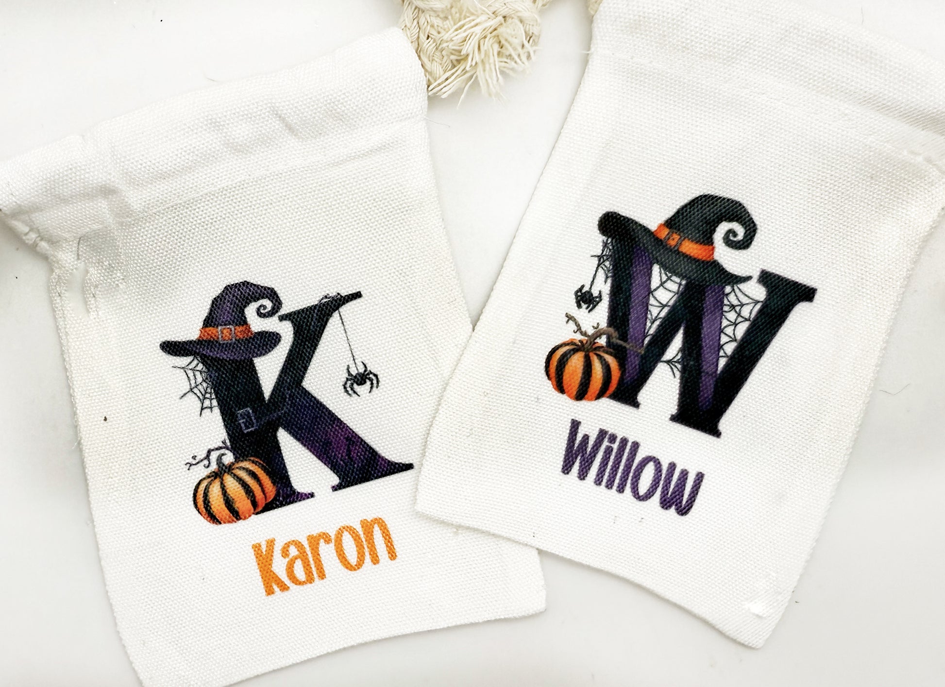 two white towels with personalized monogrammed letters and Halloween-themed illustrations.