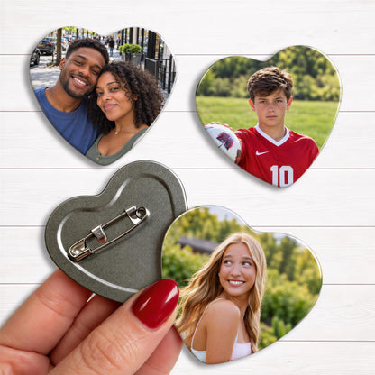 A hand holding a heart-shaped magnet with a photo of a couple and a young man in a soccer uniform, as well as a photo of a smiling blonde woman.