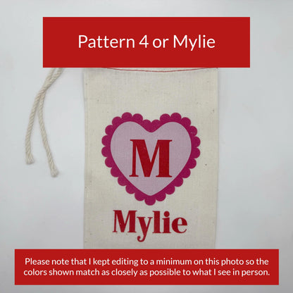 a white fabric with a pink heart-shaped logo and the name "Mylie" printed on it.