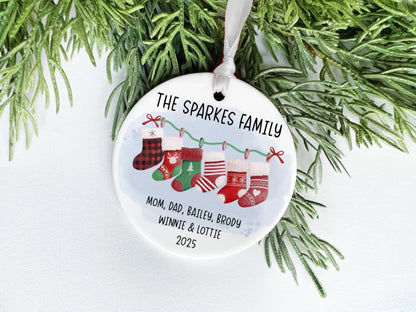 A white ceramic ornament with a Christmas tree branch and greenery, featuring a family tree design with the text "THE SPARKLES FAMILY" and the names "MOM, DAD, BAiley, BRODY, WINNIE & LOTTIE" along with the year "2025".