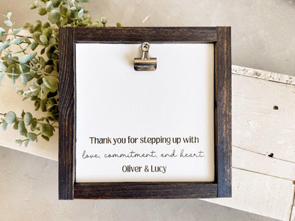 a wooden frame with a white background, containing a handwritten message expressing gratitude.