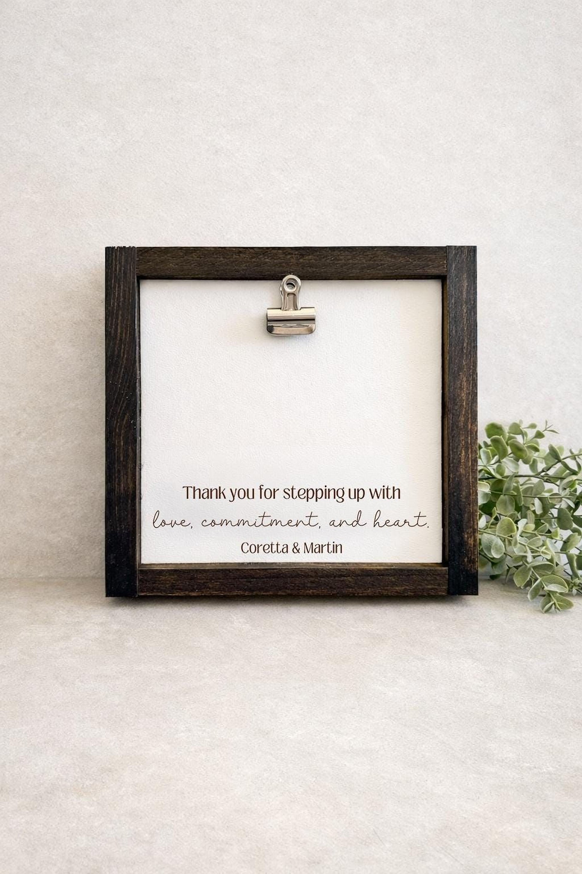 A wooden frame with a white background, displaying a message that says "Thank you for stepping up with love, commitment and heart Corotta & Martin".
