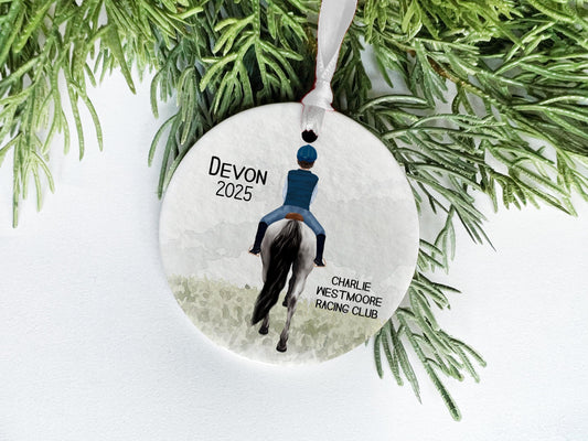 A decorative ornament featuring a person riding a horse, with the text "Devon" and "Charlie Westmore Racing Club" printed on it.