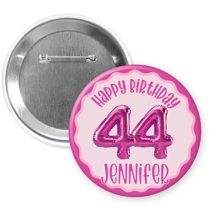 A pink birthday button with the number 44 and the name 'Jenna' printed on it.