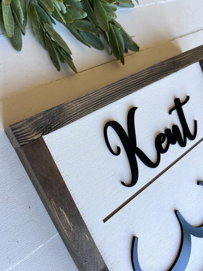 a wooden frame with the name 'Kent' written on it in a cursive font.